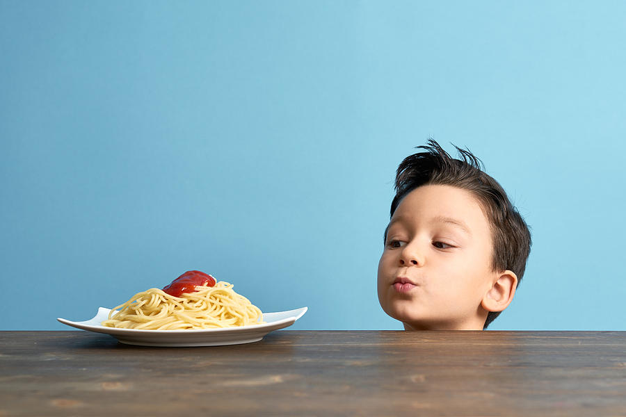 Child looking to spaghetti Photograph by Pinstock