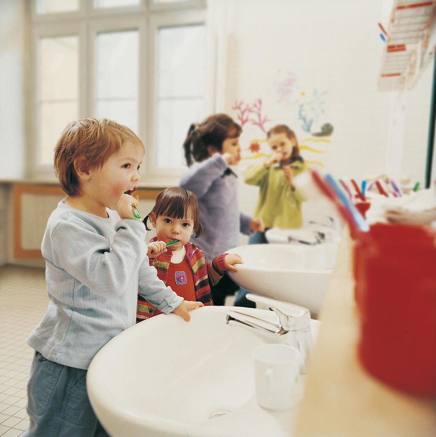 Childern in a Nursery Bathroom Brushing their Teeth Photograph by Rayman