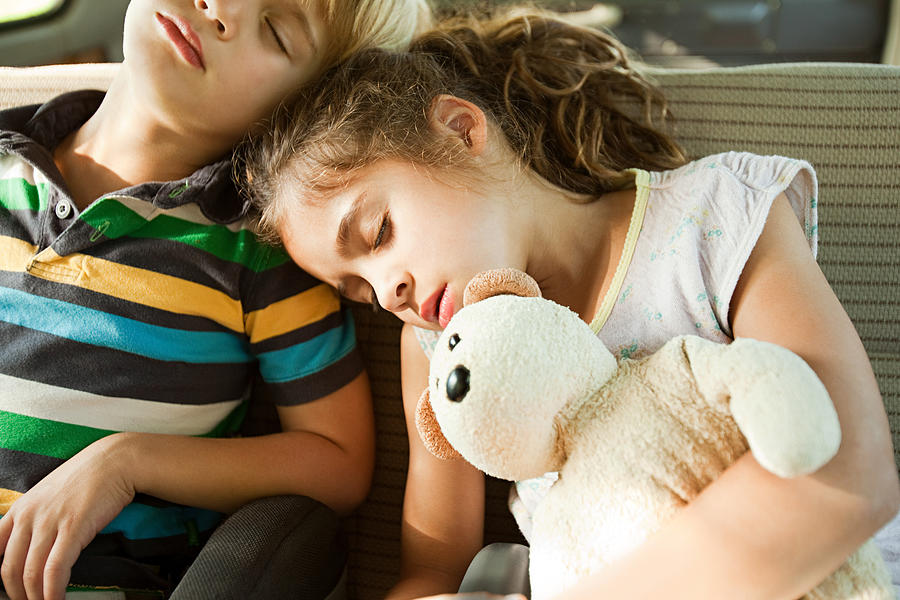 Children asleep in back seat of car Photograph by Image Source