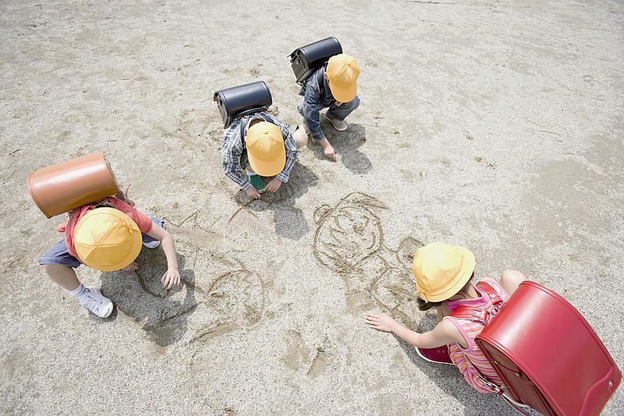 Children drawing in the sand Photograph by Image Source
