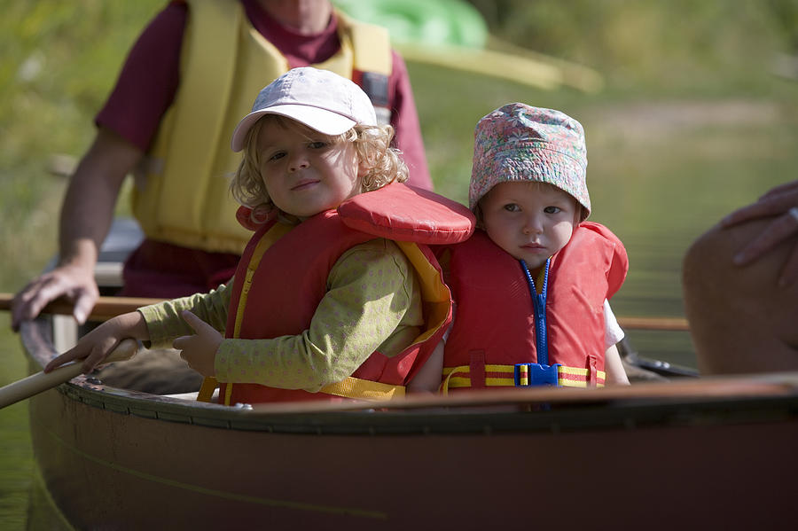 Children in canoe Photograph by Comstock Images