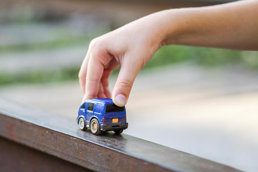 Children kid playing blue color car toy. Child hand playing with car Photograph by Andrii Zorii