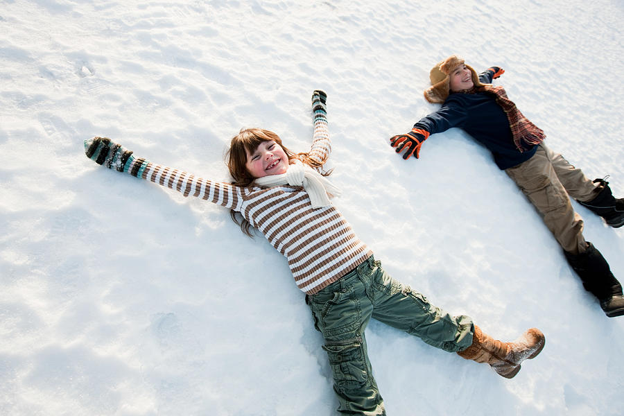 Children making snow angels Photograph by Image Source