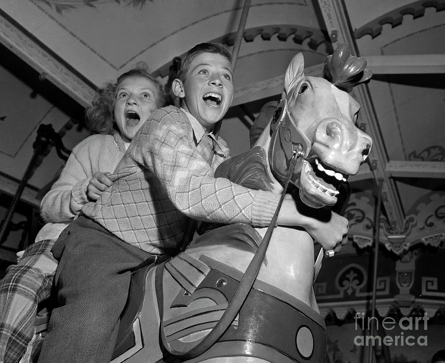 Children on a merry-go-round 1946 Photograph by The Harrington Collection