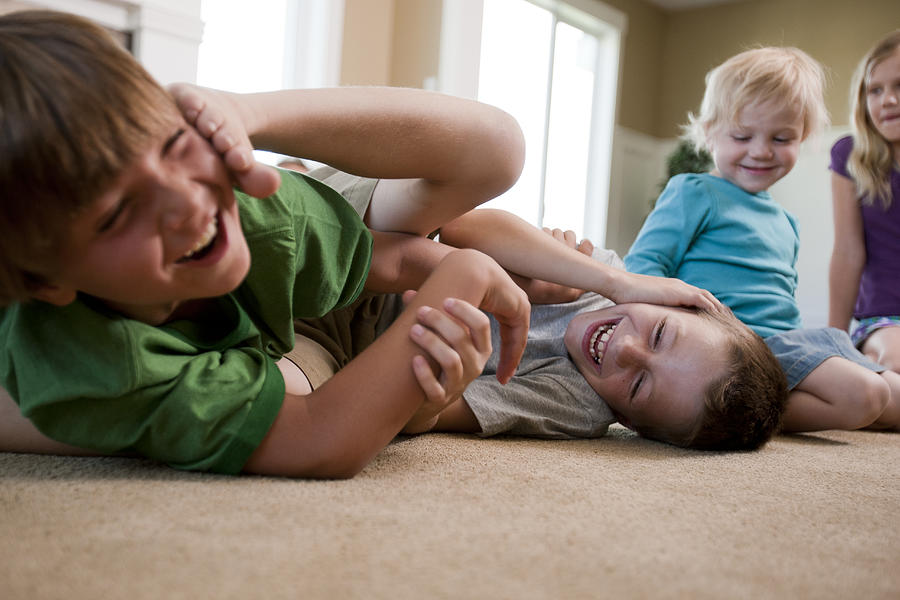 Children play fighting on floor Photograph by Tetra Images - Tim Pannell