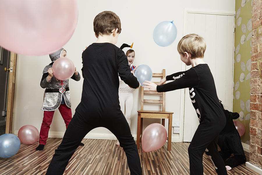 Children playing with balloons at birthday party Photograph by Emma Kim
