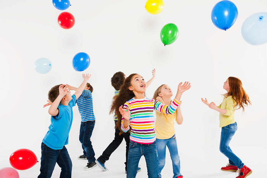 Children playing with balloons Photograph by Image Source