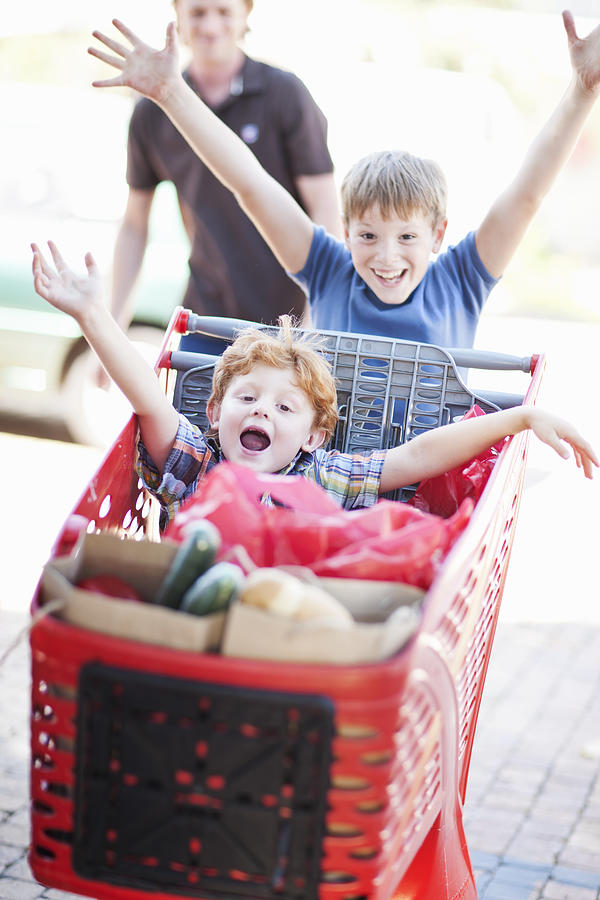 Children playing with shopping cart Photograph by Zero Creatives
