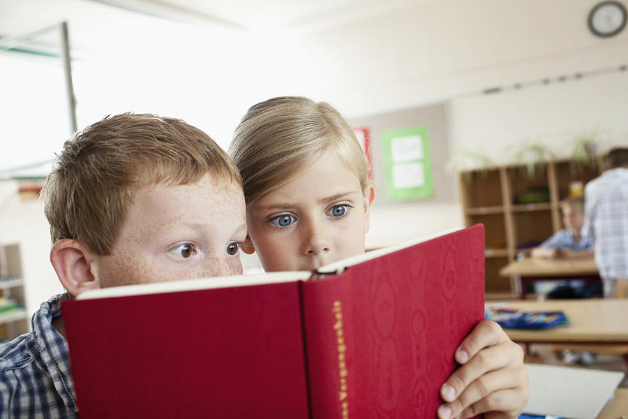 Children reading book in school Photograph by Oliver Rossi