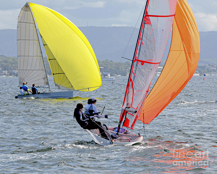 Children Sailing small sailboats with yellow and orange sails on Photograph by Geoff Childs