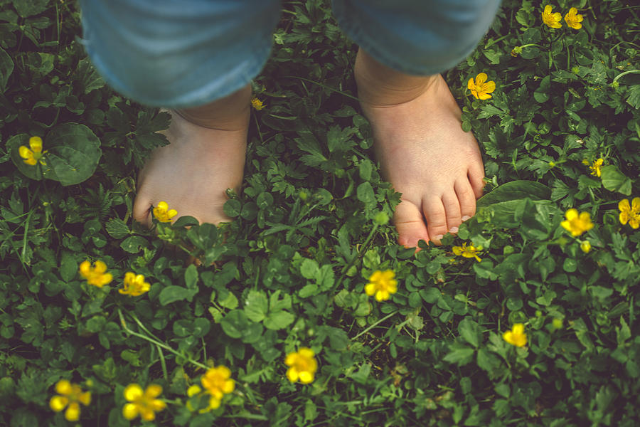 Childs feet on the green grass Photograph by ArtMarie