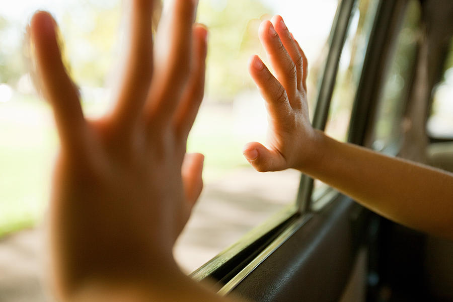 Childs hands touching car window Photograph by Image Source