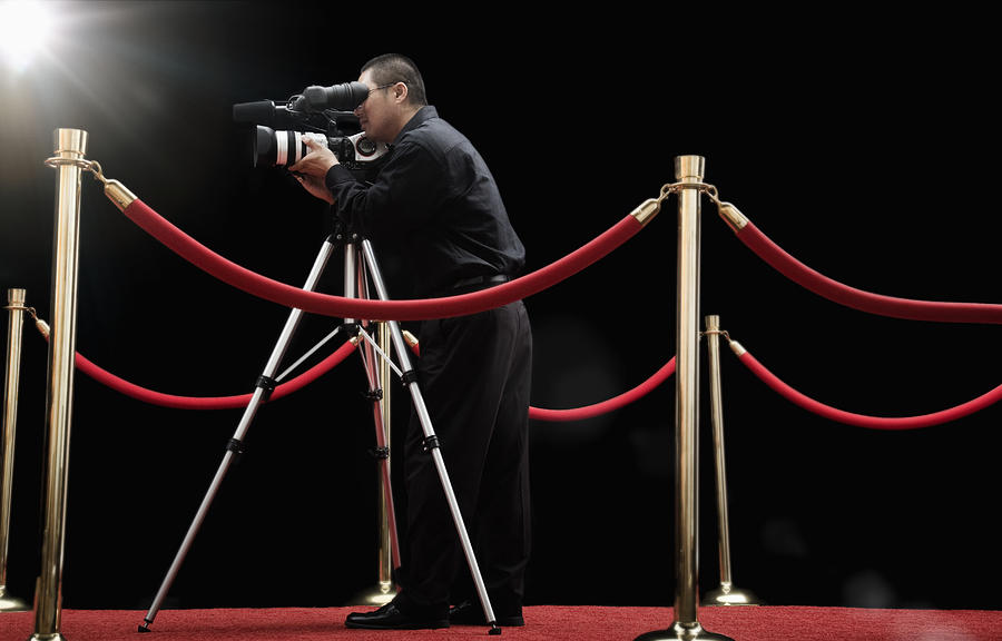 Chinese cameraman with camera on red carpet Photograph by Hill Street Studios
