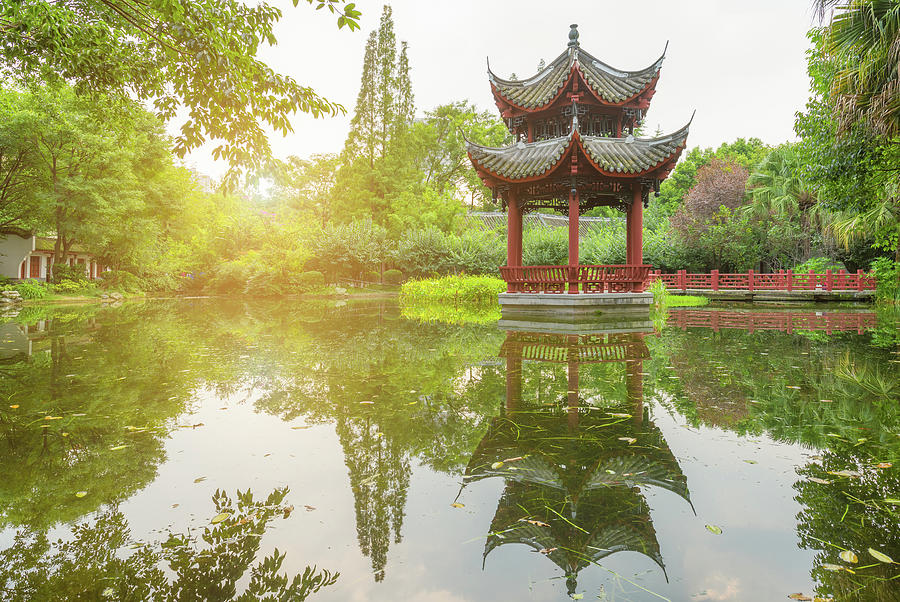 Chinese pavilion reflecting in a pond in BaiHuaTan public park Photograph by Philippe Lejeanvre