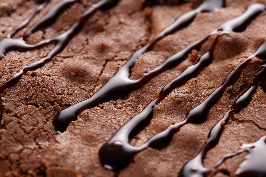 Chocolate sauce drizzled on brownie Photograph by Jupiterimages