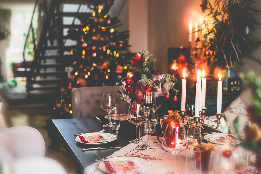 Christmas dinner table at festive cozy room background with Christmas tree Photograph by Vicuschka