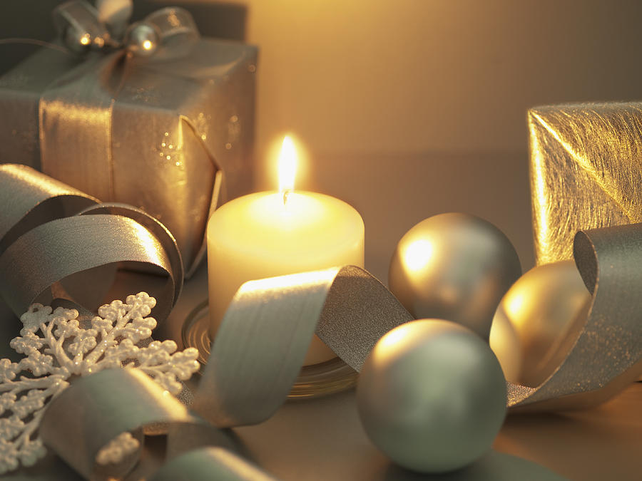Christmas gifts, ornaments and candle Photograph by Martin Barraud