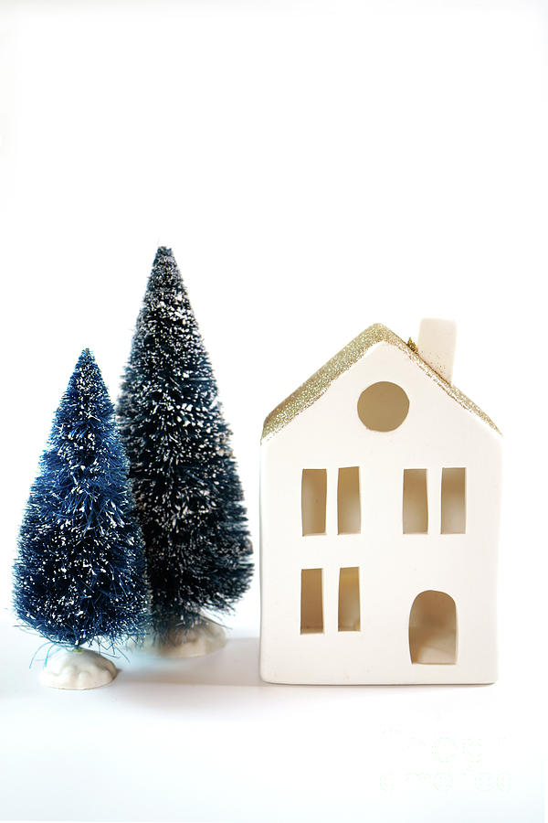 Christmas holiday background with white village house and tree ornaments. Photograph by Milleflore Images