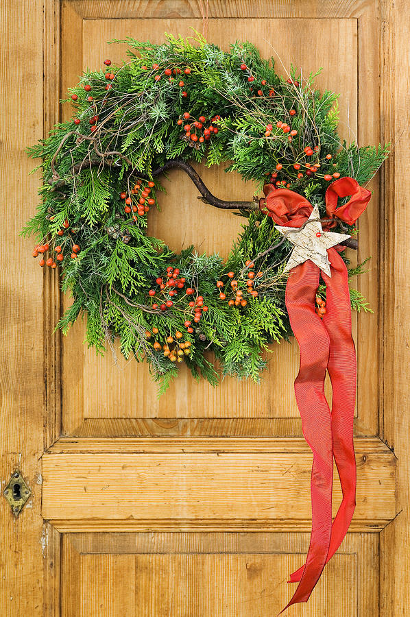 Christmas wreath on an old cupboard door Photograph by Meinrad Riedo
