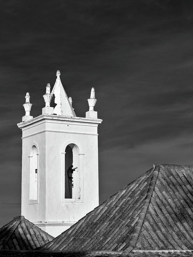 Church bell tower behind tiled roofs in Tavira Photograph by Angelo DeVal