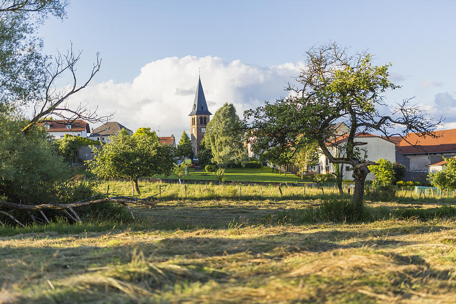 Church spire and village field in Launstroff Photograph by Merten Snijders