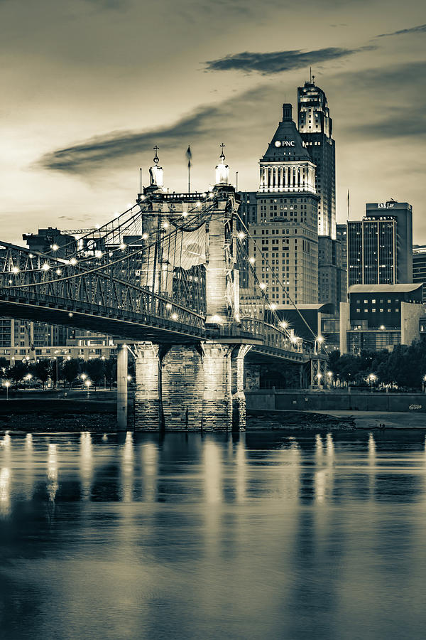 Black And White Photograph - Cincinnati Skyline and Roebling Bridge in Sepia Over The Ohio River by Gregory Ballos
