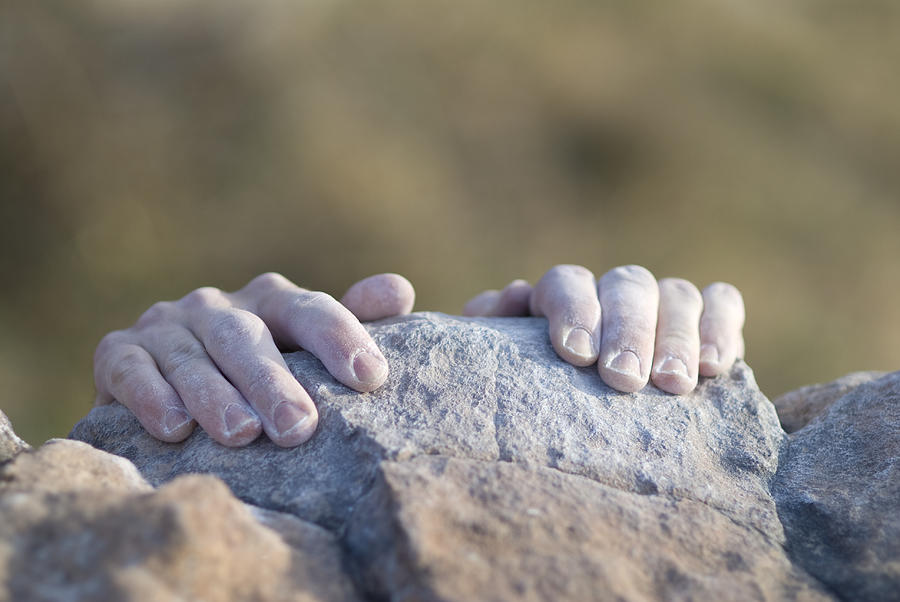Climbers hands grabbing the top of a rock ledge Photograph by Daniel H. Bailey