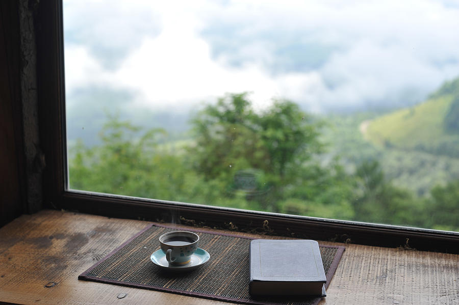 Close-up book and coffee against the beautiful view from the window Photograph by Igor Ustynskyy