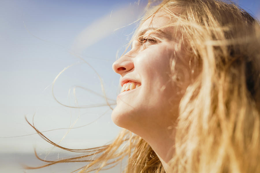 Close up carefree, smiling woman enjoying sunshine Photograph by Sven Hagolani