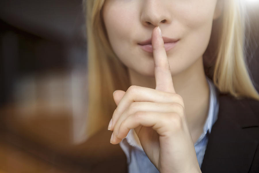 Close up cropped image of young businesswoman with finger on lips Photograph by Suedhang