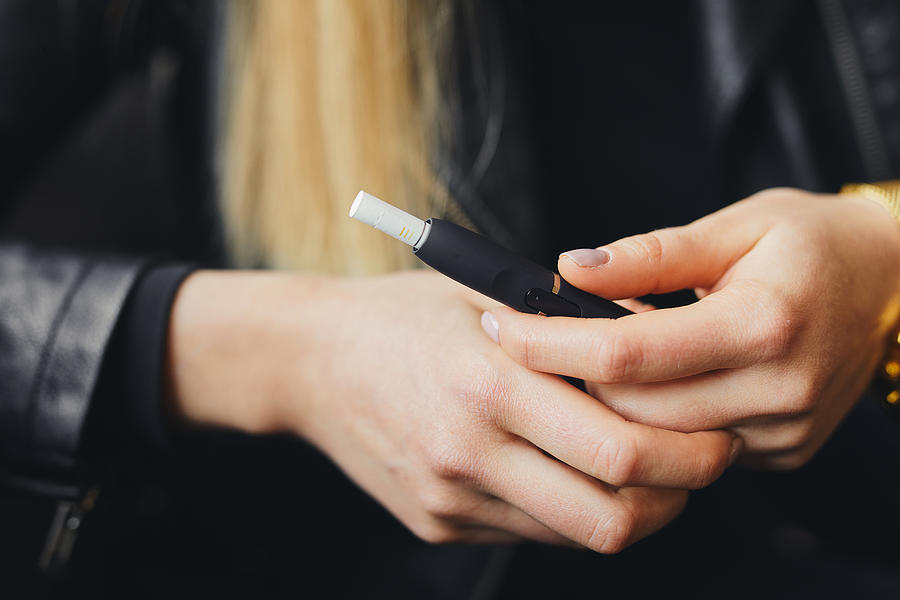 Close up electronic cigarette with case and blur girl on background Photograph by SHipskyy