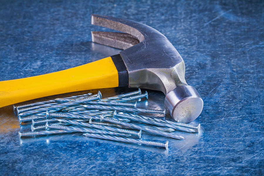 Close up image of metal construction nails with claw hammer Photograph by Mihalec