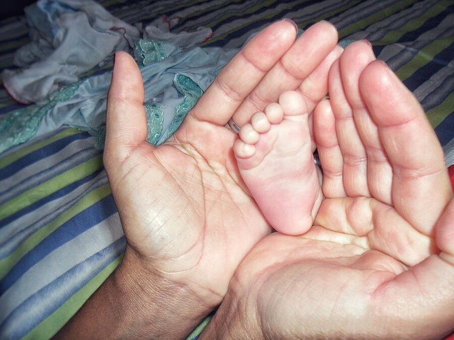 Close-up of a couples hand with babys foot Photograph by Dennis Garcia / FOAP