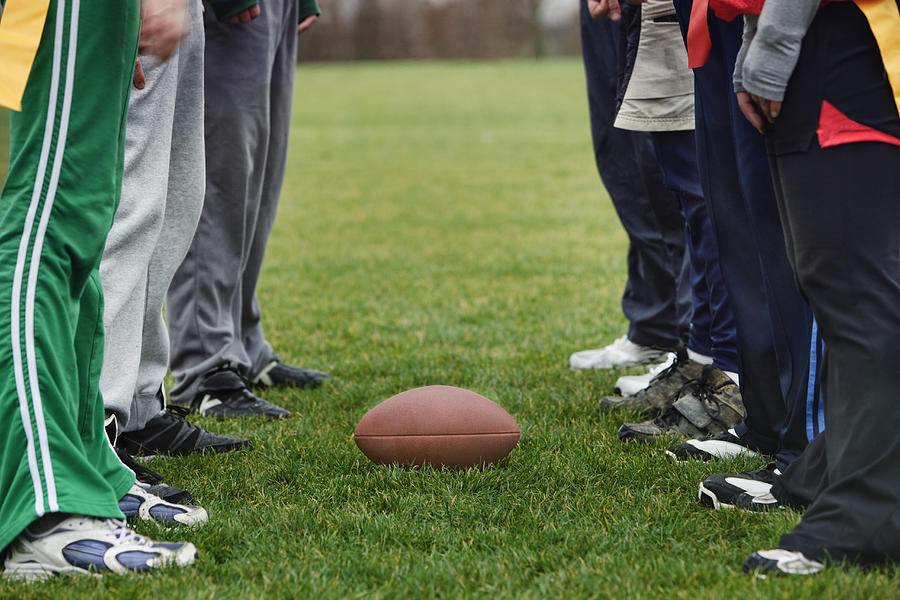 Close up of a friends getting ready for an American Flag Football game. Photograph by Mint Images
