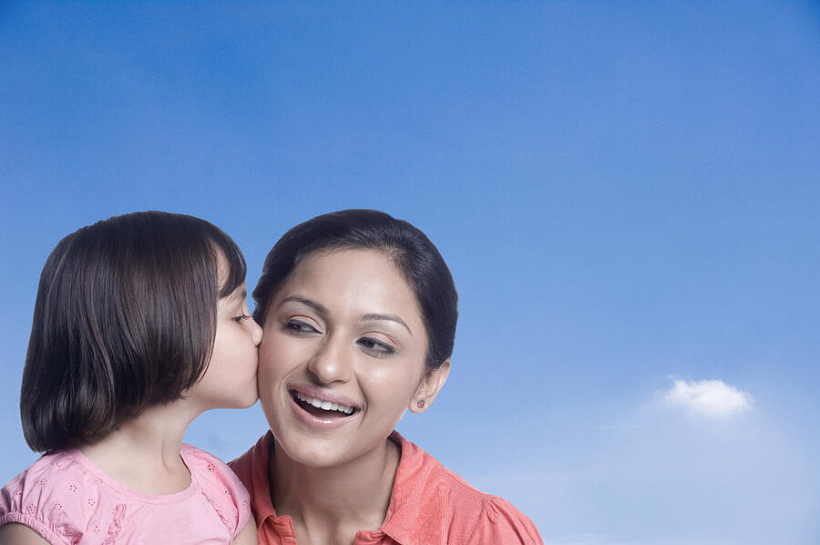 Close-up of a girl kissing her mother Photograph by Photosindia