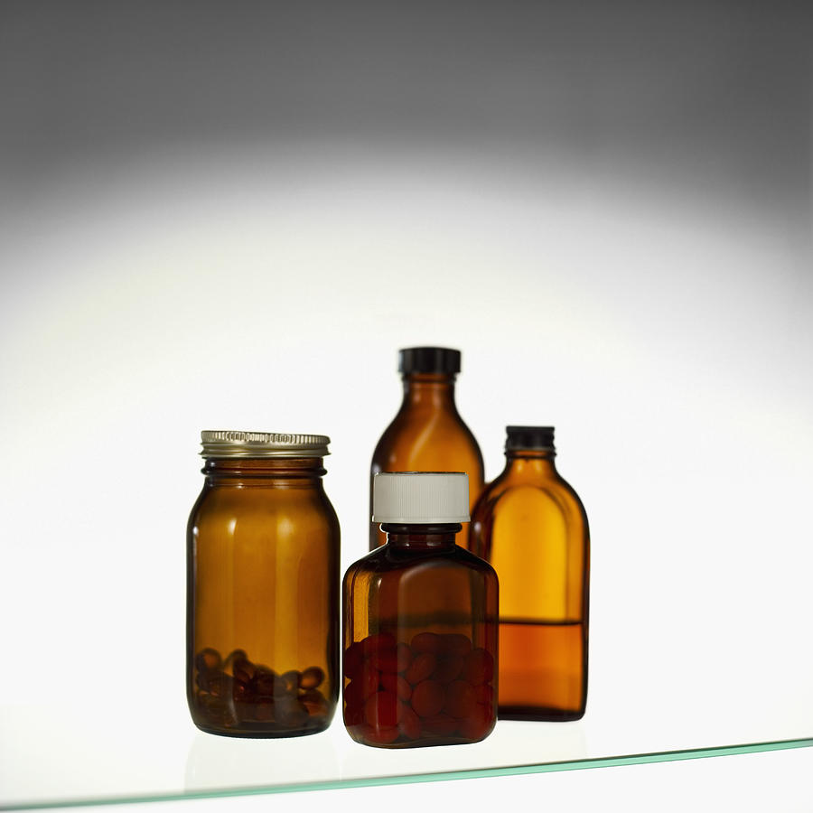 Close-up of a glass cabinet containing cough syrup and container of tablets Photograph by Stockbyte