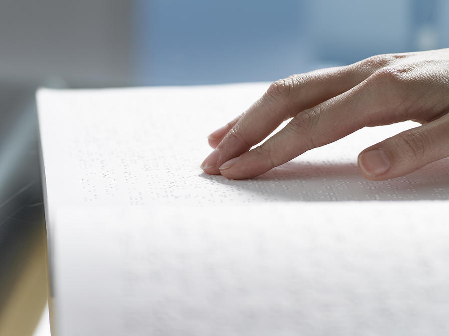 Close Up of a Hand Touching a Braille Book Photograph by Digital Vision.