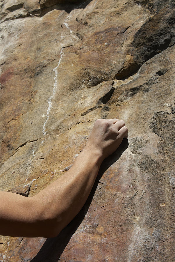 Close-up of a human arm gripping a rock Photograph by Glowimages