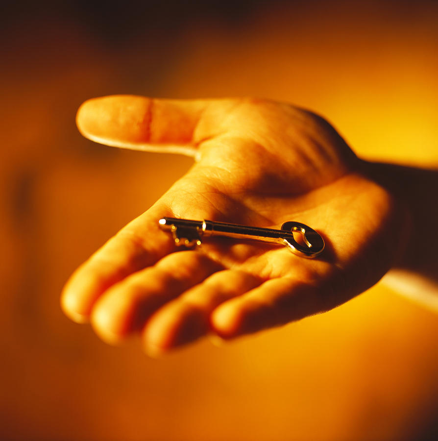 Close-up Of A Key In Persons Hand (toned) Photograph by Stockbyte