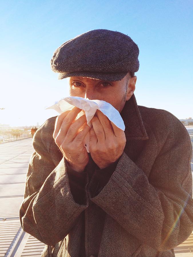 Close-up of a man blowing his nose Photograph by Nadieshda