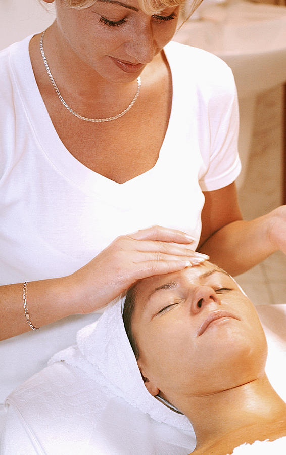 Close-up of a mid adult woman getting a massage from a massage therapist Photograph by Medioimages/Photodisc