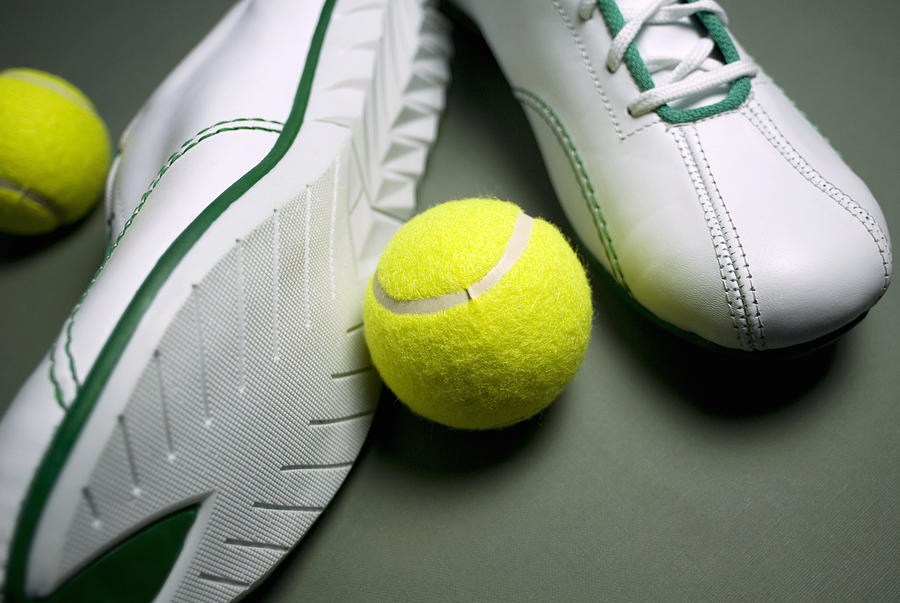 Close-up of a pair of shoes with two tennis balls Photograph by Glowimages