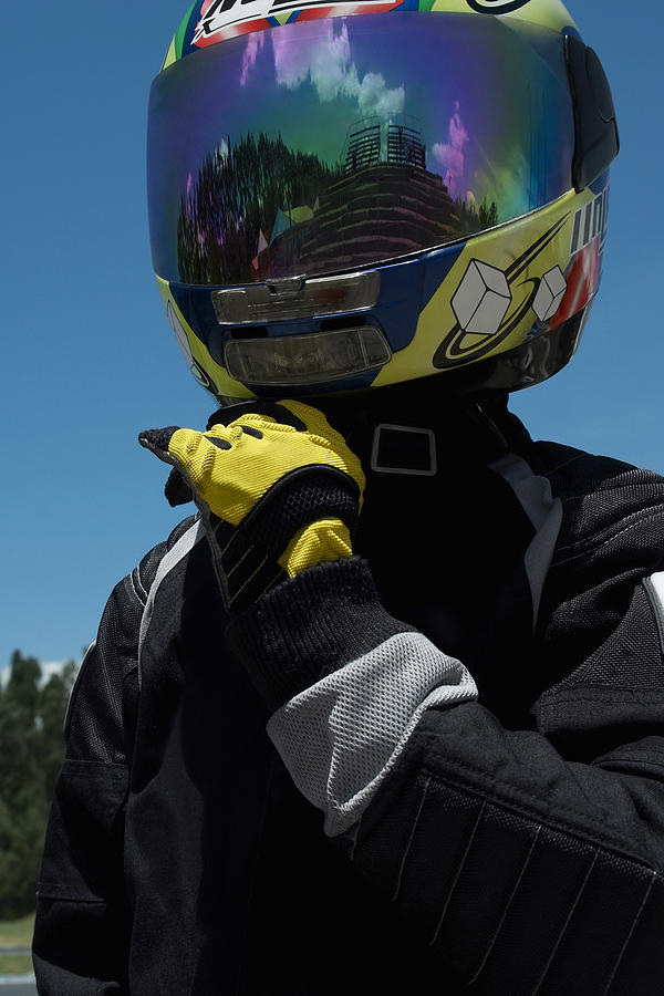 Close-up of a person adjusting his crash helmet Photograph by Glowimages