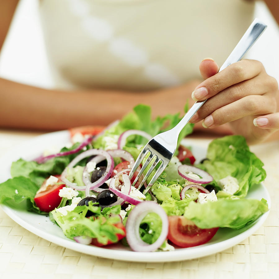 Close-up of a person eating salad with a fork Photograph by George Doyle