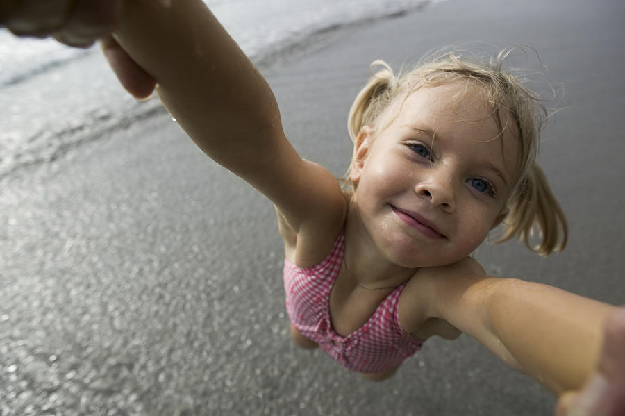 Close-up of a person spinning a girl at the beach Photograph by Photodisc