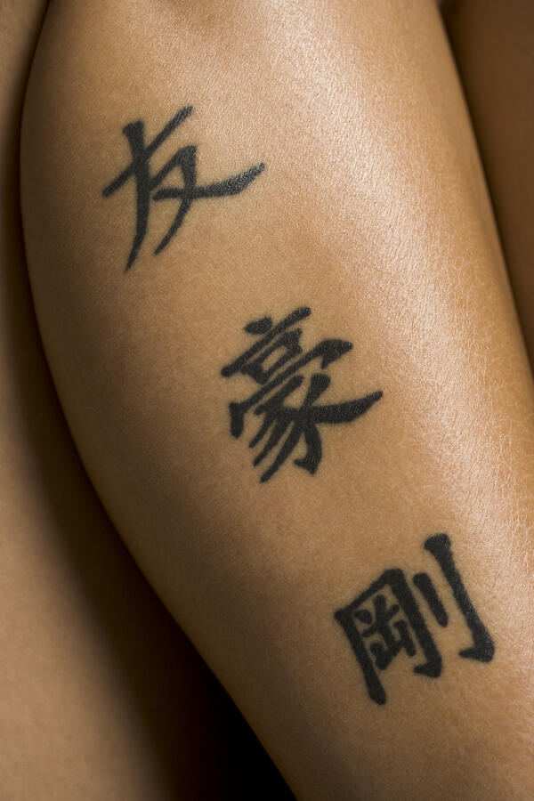 Close-up of a persons leg covered with tattoos Photograph by Photodisc