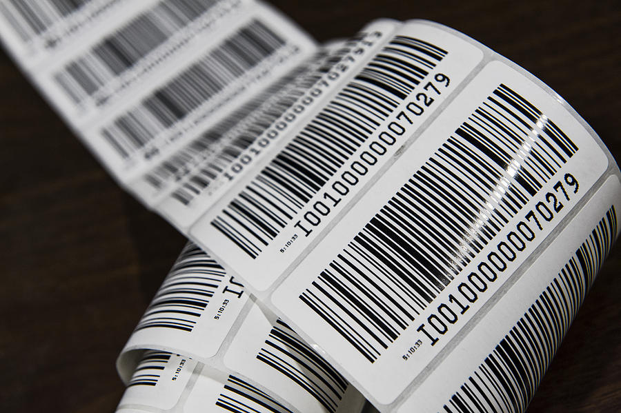 Close up of a printed barcode label on a roll, packing and distributing goods in a distribution warehouse. Photograph by Mint Images