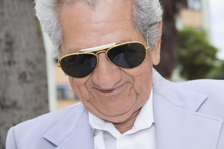 Close-up of a senior man wearing sunglasses and smiling Photograph by Glowimages