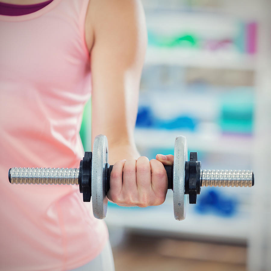 Close up of a woman lifting a dumbbell Photograph by SDI Productions