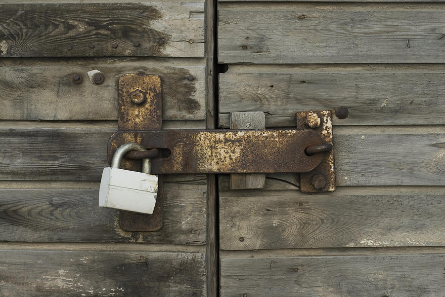 Close-up of a wooden door with a padlock Photograph by Glowimages